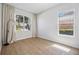 Bright bedroom featuring hardwood floors, white walls, large windows, and modern neutral-toned curtains at 312 Londonderry Dr, Sarasota, FL 34240
