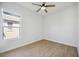 White bedroom featuring hardwood floors, a ceiling fan, a bright window, and neutral walls at 312 Londonderry Dr, Sarasota, FL 34240