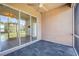 A covered lanai with slate tile flooring has a ceiling fan and sliding glass doors to the home's interior at 312 Londonderry Dr, Sarasota, FL 34240