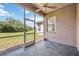 Screened patio featuring dark tile floors, a ceiling fan, and views of the green backyard at 312 Londonderry Dr, Sarasota, FL 34240