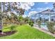 Landscaped backyard with screened pool and lush greenery at 339 Marsh Creek Rd, Venice, FL 34292