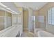 Bright bathroom with a soaking tub, a glass shower, and a double sink vanity at 339 Marsh Creek Rd, Venice, FL 34292