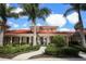 Beautiful clubhouse entrance with lush tropical landscaping and a terracotta tile roof evoking a resort feel at 339 Marsh Creek Rd, Venice, FL 34292