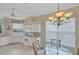 Well-lit dining space features elegant chandelier and view into kitchen at 339 Marsh Creek Rd, Venice, FL 34292