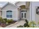 Charming front entrance with an arched entryway, decorative glass doors, and manicured landscaping at 339 Marsh Creek Rd, Venice, FL 34292