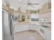 Well-lit kitchen featuring white cabinetry, modern appliances, and a view to the backyard at 339 Marsh Creek Rd, Venice, FL 34292