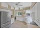 Bright kitchen with all-white appliances, bar seating, and views of the lanai and pool at 339 Marsh Creek Rd, Venice, FL 34292