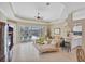 Spacious living room with tray ceilings, tile floors, comfortable seating, and view of the screened-in patio at 339 Marsh Creek Rd, Venice, FL 34292