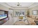 Comfortable living room with tile flooring, neutral paint, and a view of the screened-in outdoor pool area at 339 Marsh Creek Rd, Venice, FL 34292