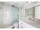 Bright bathroom featuring a walk-in shower with marble tiling and a vanity with storage at 400 Base E Ave # 213, Venice, FL 34285