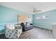 Airy bedroom with ceiling fan, wood-look floors, a couch, and a decorative headboard at 400 Base E Ave # 213, Venice, FL 34285