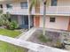 Ground floor condo unit featuring a private patio and manicured landscaping at 400 Base E Ave # 213, Venice, FL 34285