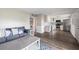 Open floor plan with hardwood style floors featuring a kitchen and a comfy living room with a couch at 400 Base E Ave # 213, Venice, FL 34285