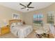 Comfortable bedroom featuring a ceiling fan, wood-look floors, and a cozy sitting area at 4301 Nizza Ct, Venice, FL 34293