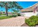 Brick driveway leads to the attached garage with a meticulously maintained lawn and manicured shrubbery at 4301 Nizza Ct, Venice, FL 34293