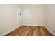 The empty bedroom features hardwood floors, white trim and plantation shutters at 448 Bocelli Dr, Nokomis, FL 34275