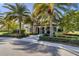Exterior shot of the Aria community clubhouse lined with beautiful palm trees and landscaping at 448 Bocelli Dr, Nokomis, FL 34275