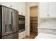 Modern kitchen featuring stainless steel appliances, double ovens, pantry, and quartz countertops at 448 Bocelli Dr, Nokomis, FL 34275