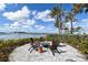 Outdoor seating area with lounge chairs surrounding a fire pit, with a serene lake view at 448 Bocelli Dr, Nokomis, FL 34275