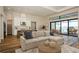 Spacious living room with modern decor, wood floors, and a beautiful view of the pool and lake at 448 Bocelli Dr, Nokomis, FL 34275