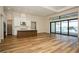 Open-concept living area featuring wood flooring, a kitchen island, and sliding glass doors to the pool area at 448 Bocelli Dr, Nokomis, FL 34275