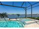 Gorgeous screened pool and spa overlooking the lake with beautiful blue tiled accents and outdoor views at 448 Bocelli Dr, Nokomis, FL 34275