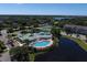 Aerial view of community pool, clubhouse, tennis courts, and surrounding lush landscape at 4802 51St W St # 1816, Bradenton, FL 34210