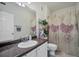 Well-lit bathroom with a granite countertop vanity, a large mirror, and a flower-patterned shower curtain at 4802 51St W St # 1816, Bradenton, FL 34210