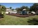 Community playground featuring swings and slides surrounded by wood chips and manicured lawn at 4802 51St W St # 1816, Bradenton, FL 34210