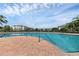 Community pool with stainless steel handrails, lush landscaping, and clear blue skies at 4802 51St W St # 1816, Bradenton, FL 34210