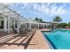 Community pool with white pergola and lounge chairs with brick paver deck under blue skies at 4802 51St W St # 1816, Bradenton, FL 34210
