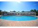 Community pool in courtyard setting with lounge chairs and clear blue skies at 4802 51St W St # 1816, Bradenton, FL 34210