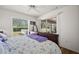 Bedroom with wood floors, a queen bed with purple bedding, sliding door to backyard at 5458 Jessamine Ave, North Port, FL 34291