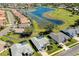 Stunning aerial view of a community with a lake, lush landscaping, and homes with private pools at 562 Silk Oak Dr, Venice, FL 34293