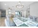 Glass dining table with seating for six and open concept view of kitchen and living room at 562 Silk Oak Dr, Venice, FL 34293