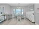 Dining room with large windows, a glass table, and seating for six, lit by a chandelier at 562 Silk Oak Dr, Venice, FL 34293