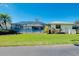 Attractive home featuring a screened-in pool, vibrant landscaping, and a well-kept lawn at 562 Silk Oak Dr, Venice, FL 34293