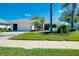 Charming single-story home with a well-manicured lawn, mature trees, and a two-car garage at 562 Silk Oak Dr, Venice, FL 34293