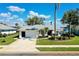 Well-maintained home featuring a lush green lawn and tropical landscaping at 562 Silk Oak Dr, Venice, FL 34293