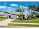 Well-maintained home featuring a lush green lawn and tropical landscaping at 562 Silk Oak Dr, Venice, FL 34293
