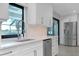 Modern kitchen with white cabinets, quartz countertops, stainless steel appliances, and a view of the outdoors at 562 Silk Oak Dr, Venice, FL 34293