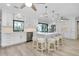 Bright kitchen features white cabinets, stainless steel appliances, a large island with seating, and wood flooring at 562 Silk Oak Dr, Venice, FL 34293