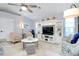 Inviting living room featuring a comfortable seating arrangement, a ceiling fan, and a stylish entertainment center at 562 Silk Oak Dr, Venice, FL 34293