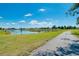 Scenic walking path with lush green lawns, mature trees, and serene water views, perfect for leisurely strolls at 562 Silk Oak Dr, Venice, FL 34293