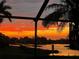 Stunning sunset view overlooking a tranquil lake from a screened lanai at 562 Silk Oak Dr, Venice, FL 34293