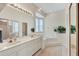 Bright bathroom featuring a double vanity, large mirror and a garden tub for a relaxing and spa-like experience at 571 Catalina Isles Cir, Venice, FL 34292