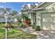 Charming home featuring a lush landscaped yard with a walkway leading to a light colored front door at 571 Catalina Isles Cir, Venice, FL 34292