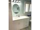 Bathroom with white vanity, modern fixtures, and a large mirror, bathed in natural light at 599 Carmel Rd, Venice, FL 34293
