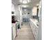 Modern white kitchen featuring stone countertops, stainless appliances, and streamlined design at 599 Carmel Rd, Venice, FL 34293