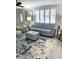 Cozy living room with plantation shutters, stylish blue sofa, and decorative rug at 599 Carmel Rd, Venice, FL 34293